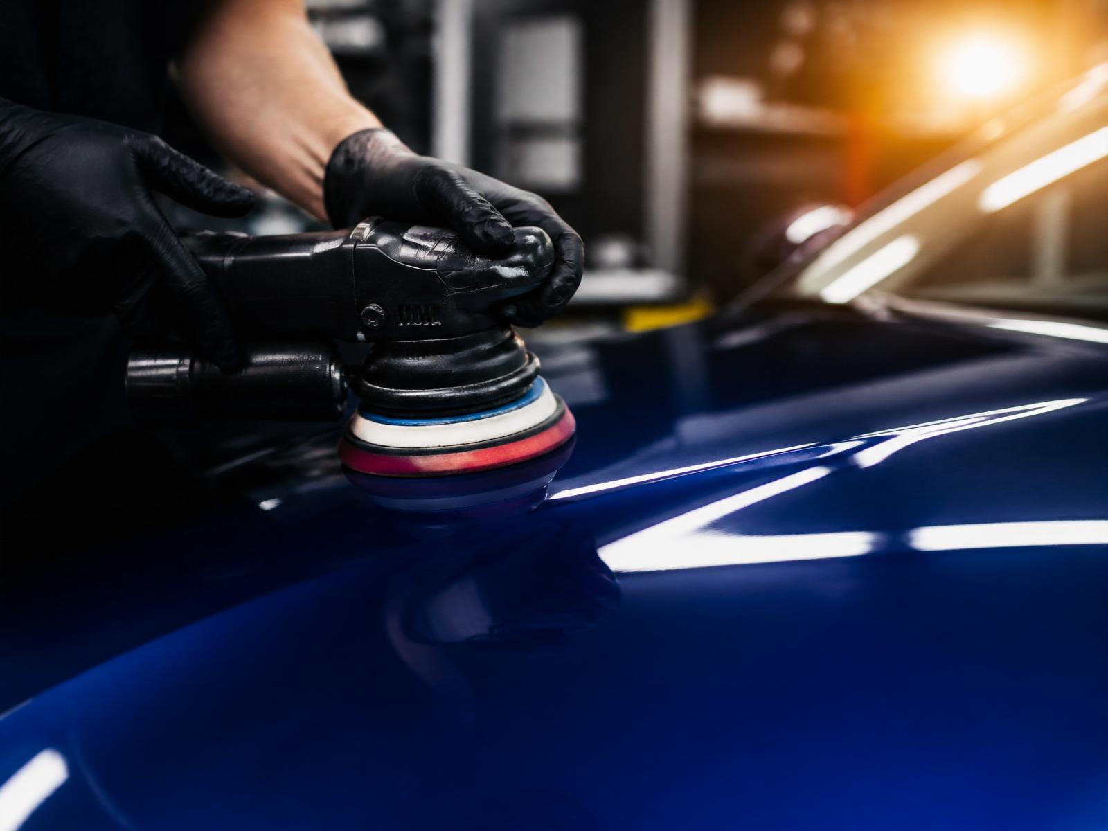 Close-up of a master auto body technician's hands sanding a car panel by hand at CT Collision in Kissimmee, Florida